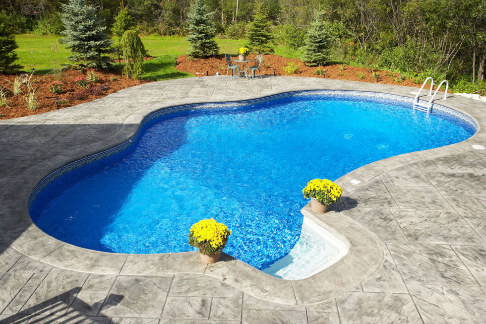 Pretty blue pool with yellow flowers on decking